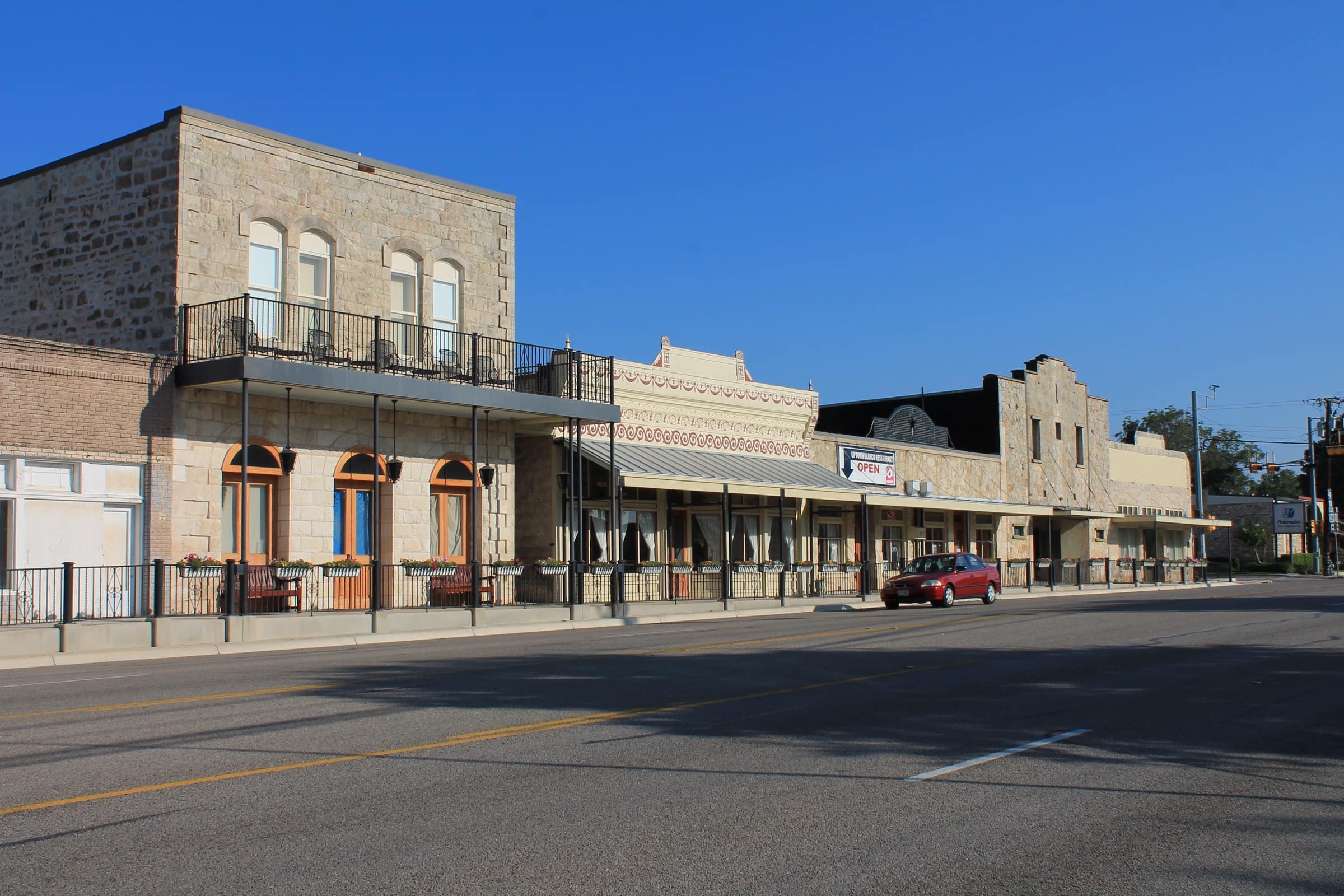 A row of 19th-century limestone storefronts on Main Street in the Blanco Historic District
